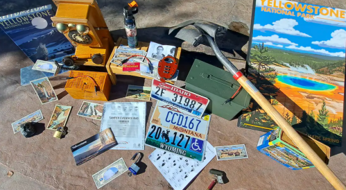 A collection of vintage items and memorabilia related to Yellowstone National Park, including maps, photos, and tools.